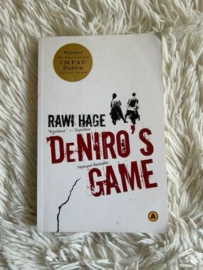 Deniro's Game - by Rawi Hage, award winner, White & Red Paperback Book